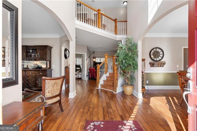 1070 Cureton Dr, Austell, GA 30106 - entrance foyer featuring arched walkways, wood-type flooring, stairs, a towering ceiling, and crown molding