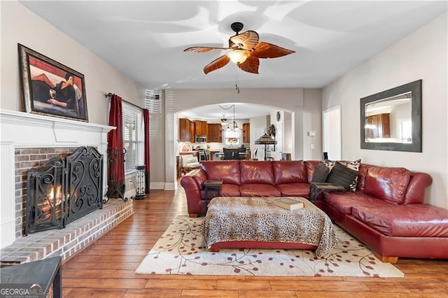 1070 Cureton Dr, Austell, GA 30106 - living area featuring arched walkways, a ceiling fan, hardwood / wood-style flooring, and a fireplace