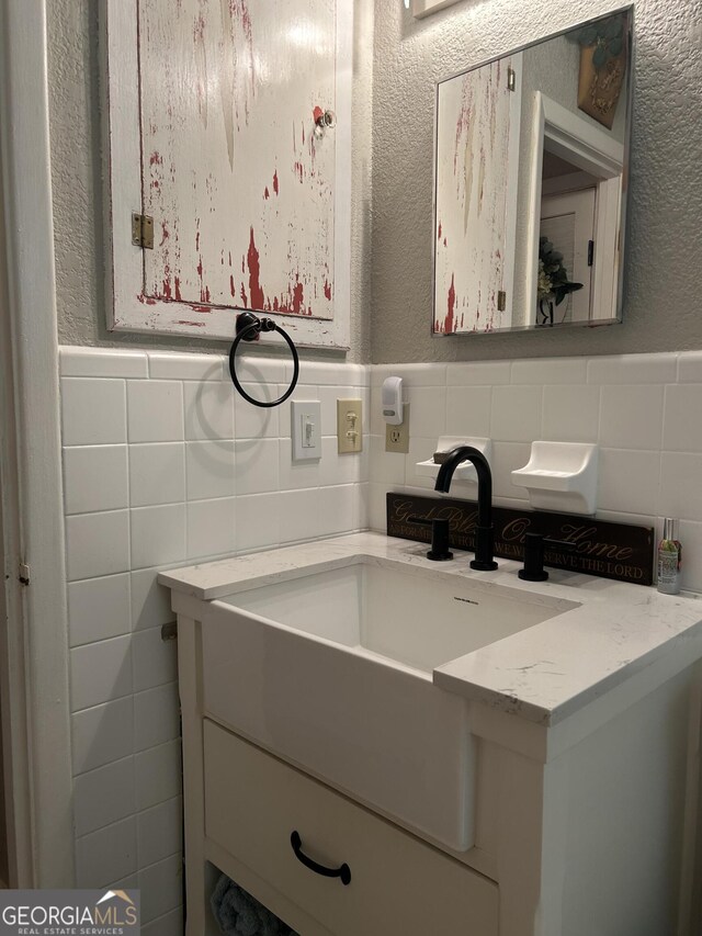 815 W Crawford St, Dalton, GA 30720 - bathroom with tile walls, a textured wall, vanity, and wainscoting