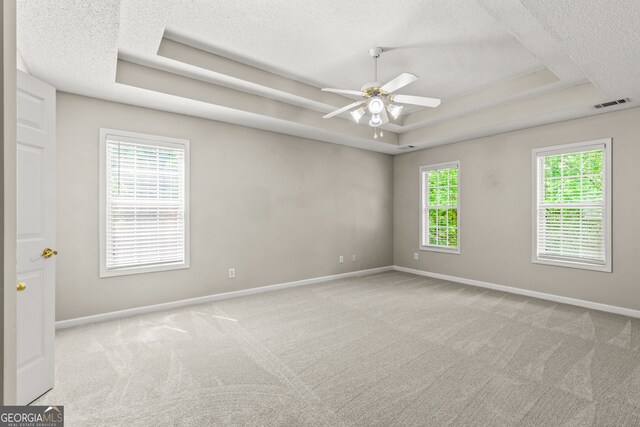 220 Drumcliff Ct, Tyrone, GA 30290 - carpeted empty room featuring a tray ceiling, a textured ceiling, baseboards, and a ceiling fan