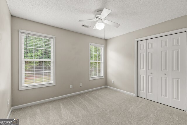220 Drumcliff Ct, Tyrone, GA 30290 - unfurnished bedroom featuring a textured ceiling, carpet, baseboards, a closet, and a ceiling fan