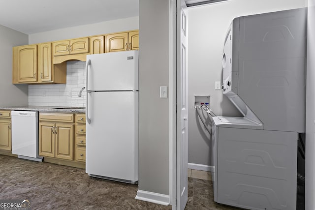624 Lyle Dr SE, Marietta, GA 30067 - kitchen featuring white appliances, stacked washing machine and dryer, a sink, tasteful backsplash, and baseboards