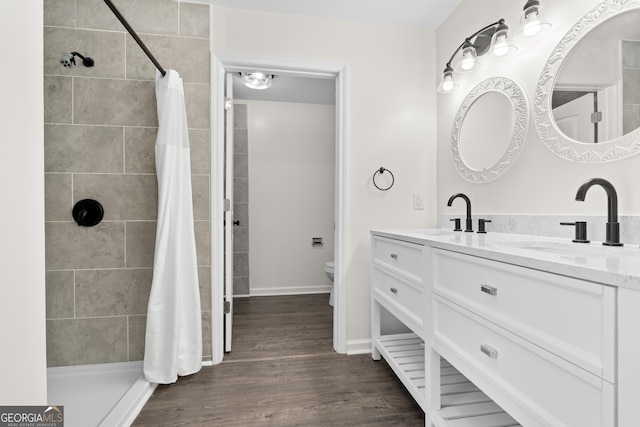 9 Wimbledon Ct, Statesboro, GA 30458 - bathroom with double vanity, toilet, tiled shower, and wood finished floors