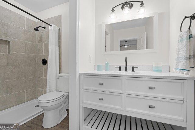 9 Wimbledon Ct, Statesboro, GA 30458 - bathroom with toilet, vanity, a ceiling fan, a tile shower, and wood finished floors