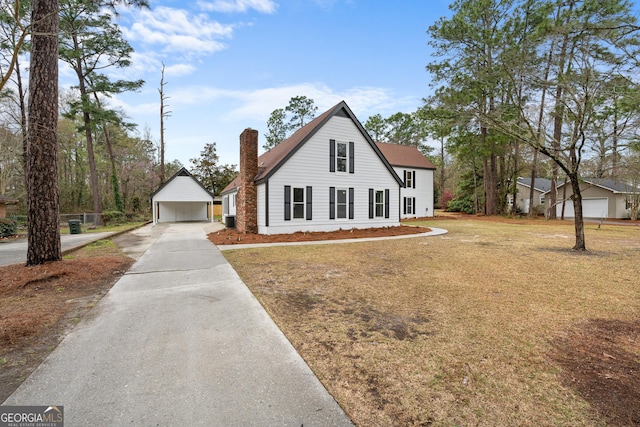 9 Wimbledon Ct, Statesboro, GA 30458 - view of front of home featuring a chimney, driveway, an outdoor structure, and a front lawn