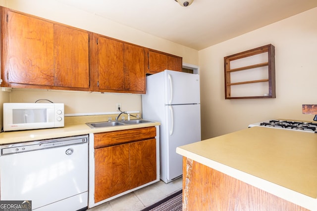 1268 Thomas Rd, Decatur, GA 30030 - kitchen with white appliances, a sink, light countertops, brown cabinetry, and light tile patterned floors