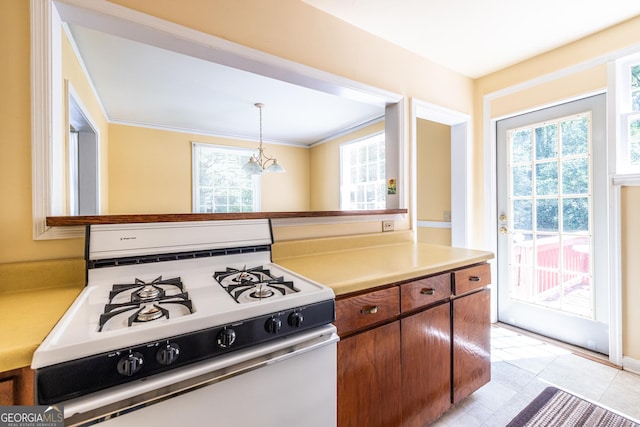 1268 Thomas Rd, Decatur, GA 30030 - kitchen with white gas range, healthy amount of natural light, light countertops, pendant lighting, and ornamental molding
