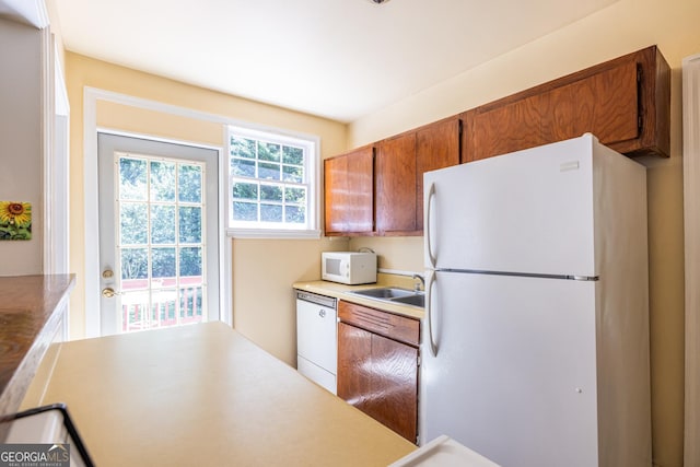 1268 Thomas Rd, Decatur, GA 30030 - kitchen featuring white appliances, a sink, brown cabinets, and light countertops
