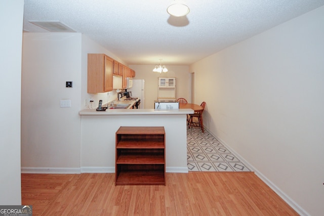 2191 Rockbridge Rd Unit 103, Stone Mountain, GA 30087 - kitchen featuring a chandelier, light wood-type flooring, light countertops, and freestanding refrigerator