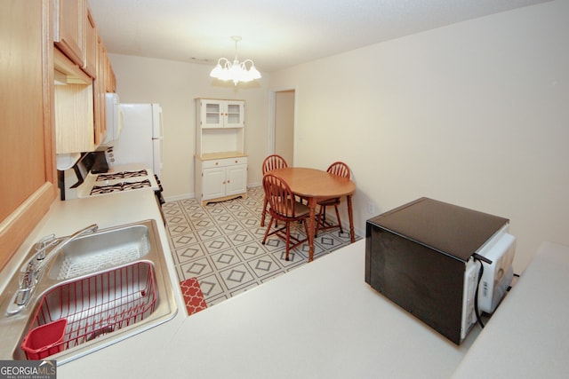 2191 Rockbridge Rd Unit 103, Stone Mountain, GA 30087 - kitchen featuring white appliances, a chandelier, a sink, pendant lighting, and light countertops