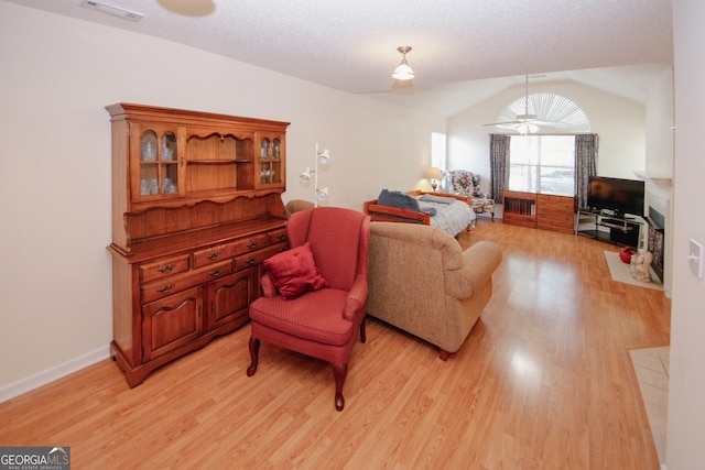 2191 Rockbridge Rd Unit 103, Stone Mountain, GA 30087 - living room featuring light wood-style floors, vaulted ceiling, baseboards, and a textured ceiling