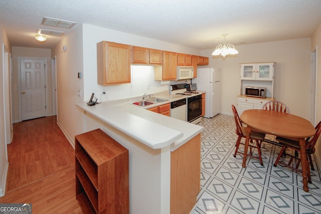 2191 Rockbridge Rd Unit 103, Stone Mountain, GA 30087 - kitchen featuring white appliances, a sink, light countertops, a chandelier, and pendant lighting