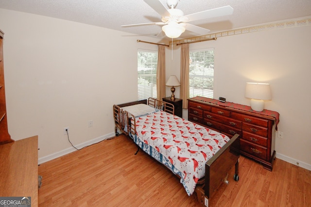 2191 Rockbridge Rd Unit 103, Stone Mountain, GA 30087 - bedroom with light wood-type flooring, baseboards, a textured ceiling, and ceiling fan
