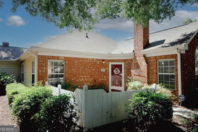 2191 Rockbridge Rd Unit 103, Stone Mountain, GA 30087 - doorway to property with brick siding, a chimney, and a gate