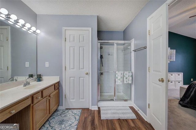 2908 Cottesford Way, Smyrna, GA 30080 - full bathroom featuring wood finished floors, a stall shower, vanity, baseboards, and a textured ceiling