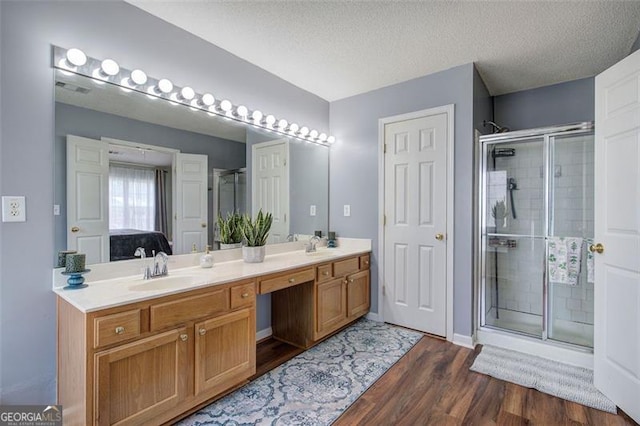 2908 Cottesford Way, Smyrna, GA 30080 - bathroom featuring wood finished floors, double vanity, a shower stall, and a textured ceiling