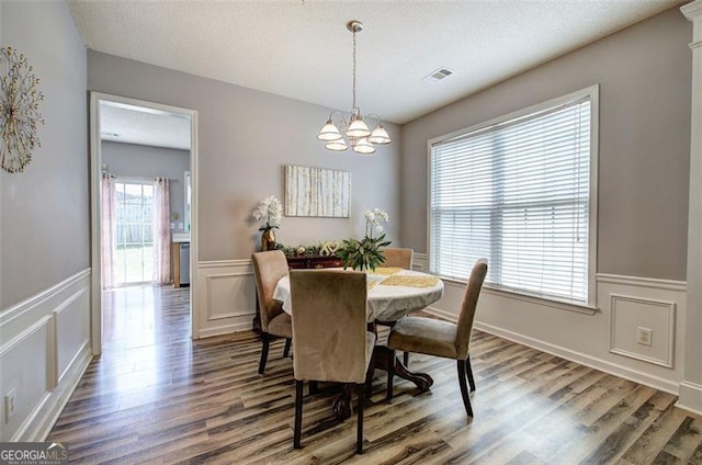 2908 Cottesford Way, Smyrna, GA 30080 - dining room featuring a chandelier, wood finished floors, a decorative wall, and wainscoting