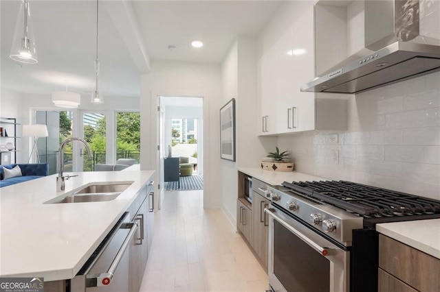 775 Juniper St NE Unit 405, Atlanta, GA 30308 - kitchen with stainless steel appliances, wall chimney exhaust hood, a sink, modern cabinets, and light countertops