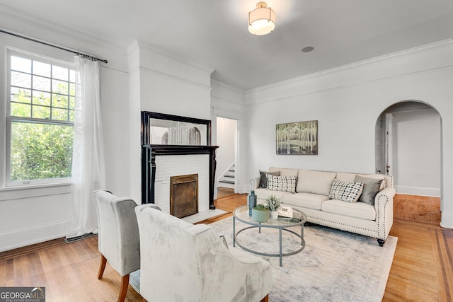 1157 Alta Ave NE, Atlanta, GA 30307 - living room with ornamental molding, a fireplace, arched walkways, healthy amount of natural light, and light wood-type flooring
