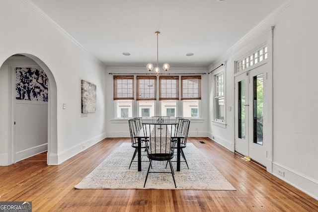 1157 Alta Ave NE, Atlanta, GA 30307 - dining area featuring plenty of natural light, crown molding, light wood finished floors, arched walkways, and a chandelier