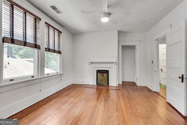 1157 Alta Ave NE, Atlanta, GA 30307 - unfurnished living room with light wood finished floors, a fireplace, a ceiling fan, and baseboards