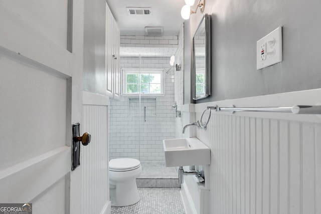 1157 Alta Ave NE, Atlanta, GA 30307 - full bathroom with toilet, a stall shower, tile patterned flooring, a wainscoted wall, and a sink