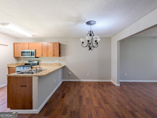 2918 Pavia Cir, Austell, GA 30106 - kitchen with appliances with stainless steel finishes, dark wood finished floors, a sink, a peninsula, and a chandelier
