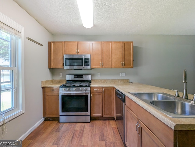 2918 Pavia Cir, Austell, GA 30106 - kitchen featuring appliances with stainless steel finishes, a sink, wood finished floors, light countertops, and a textured ceiling