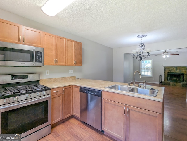 2918 Pavia Cir, Austell, GA 30106 - kitchen with stainless steel appliances, a sink, light wood-style floors, a chandelier, and light countertops