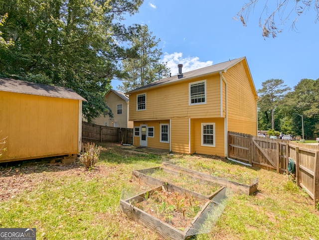2918 Pavia Cir, Austell, GA 30106 - rear view of house featuring a vegetable garden and a gate