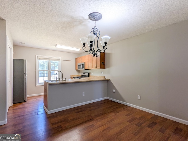 2918 Pavia Cir, Austell, GA 30106 - kitchen featuring appliances with stainless steel finishes, a sink, a peninsula, dark wood-type flooring, and a chandelier