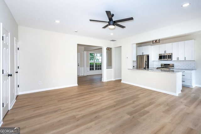 2915 Commonwealth Cir, Alpharetta, GA 30004 - unfurnished living room with a ceiling fan, light wood finished floors, recessed lighting, and baseboards