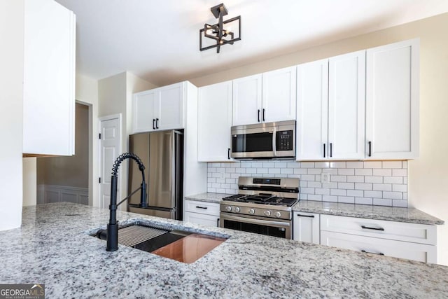 2915 Commonwealth Cir, Alpharetta, GA 30004 - kitchen featuring appliances with stainless steel finishes, a sink, white cabinets, and light stone counters