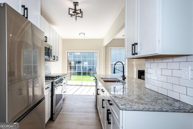 2915 Commonwealth Cir, Alpharetta, GA 30004 - kitchen featuring appliances with stainless steel finishes, a sink, tasteful backsplash, and white cabinetry