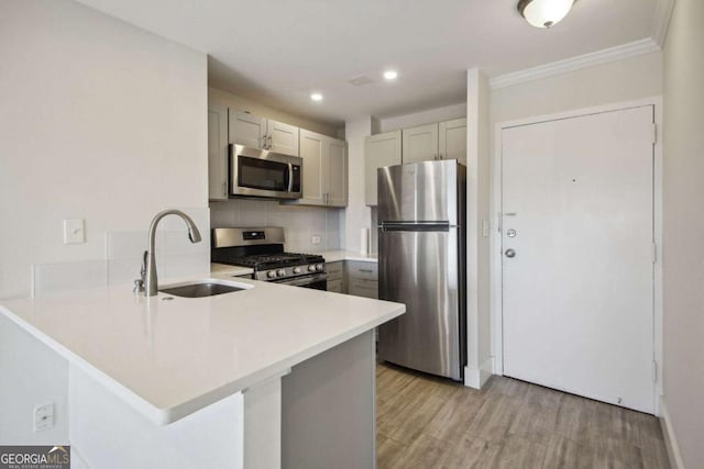 2285 Peachtree Rd NE, Atlanta, GA 30309 - kitchen featuring appliances with stainless steel finishes, a sink, a peninsula, light wood-type flooring, and light countertops