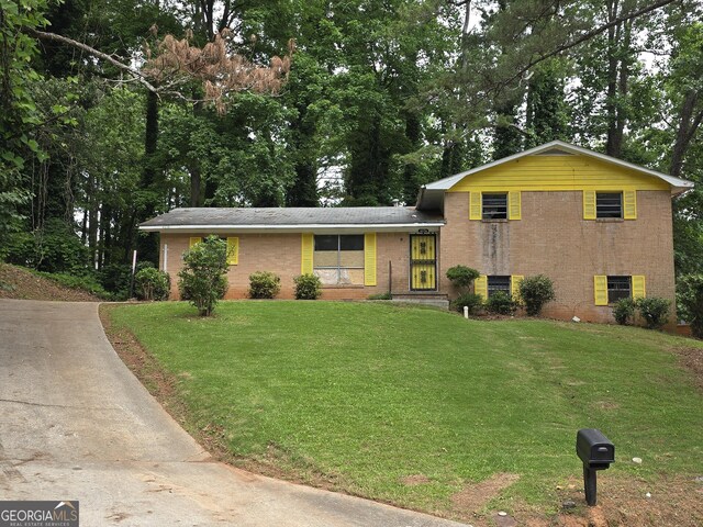 4274 Kimball Rd SW, Atlanta, GA 30331 - split level home with a front lawn, brick siding, concrete driveway, and view of scattered trees