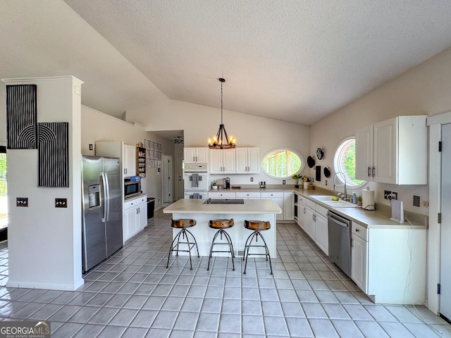 134 Roy Dean Rd, Buchanan, GA 30113 - kitchen featuring appliances with stainless steel finishes, a breakfast bar, a sink, a center island, and a chandelier