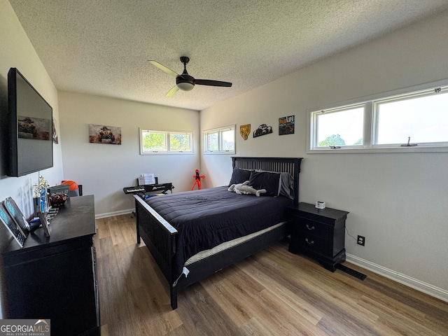 134 Roy Dean Rd, Buchanan, GA 30113 - bedroom with a textured ceiling, wood finished floors, multiple windows, baseboards, and a ceiling fan