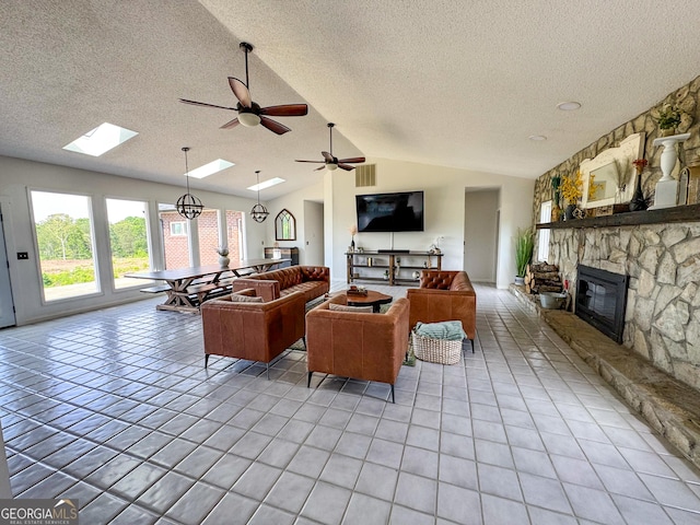 134 Roy Dean Rd, Buchanan, GA 30113 - living room with a textured ceiling, light tile patterned floors, vaulted ceiling, a ceiling fan, and a stone fireplace