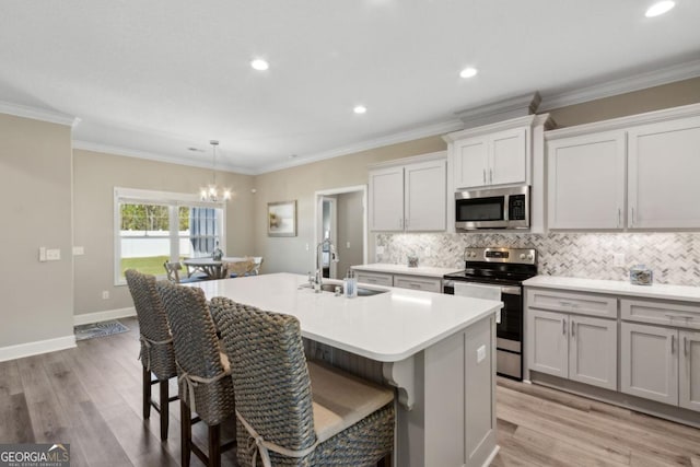 194 Pistachio Ln, Kingsland, GA 31548 - kitchen featuring appliances with stainless steel finishes, a sink, a chandelier, a center island with sink, and decorative backsplash