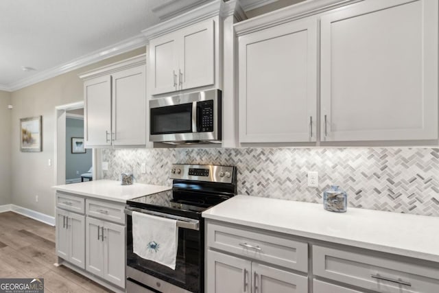 194 Pistachio Ln, Kingsland, GA 31548 - kitchen featuring stainless steel appliances, crown molding, light countertops, and backsplash