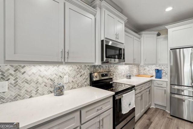194 Pistachio Ln, Kingsland, GA 31548 - kitchen featuring stainless steel appliances, light countertops, ornamental molding, backsplash, and light wood-type flooring