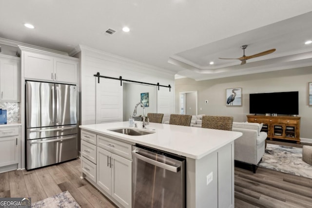 194 Pistachio Ln, Kingsland, GA 31548 - kitchen with stainless steel appliances, ornamental molding, a sink, a barn door, and a ceiling fan