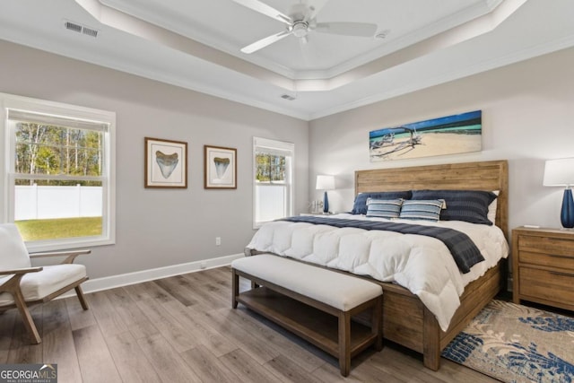 194 Pistachio Ln, Kingsland, GA 31548 - bedroom featuring a tray ceiling, crown molding, wood finished floors, multiple windows, and baseboards