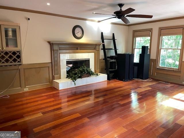 3120 Saint Andrews Cir, Duluth, GA 30096 - unfurnished living room with crown molding, wood finished floors, a wainscoted wall, ceiling fan, and a fireplace