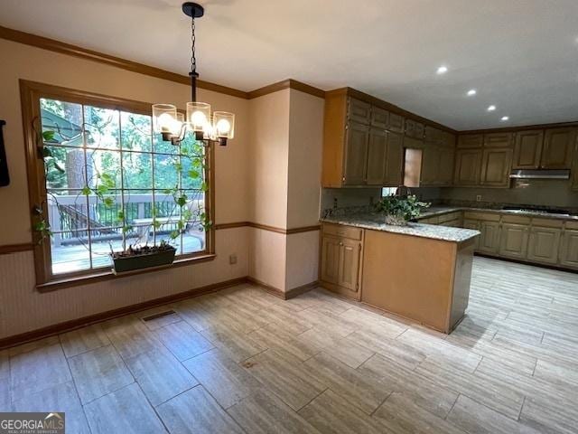 3120 Saint Andrews Cir, Duluth, GA 30096 - kitchen with a peninsula, under cabinet range hood, healthy amount of natural light, a chandelier, and crown molding