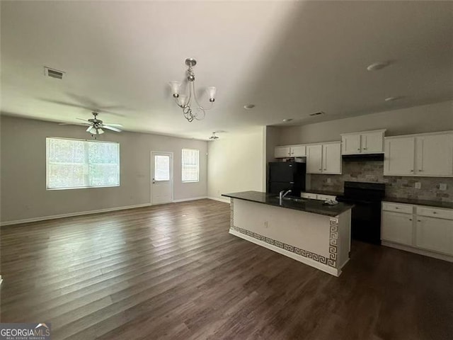 6446 Grey Fox Way, Riverdale, GA 30296 - kitchen with stove, dark countertops, freestanding refrigerator, open floor plan, and white cabinets