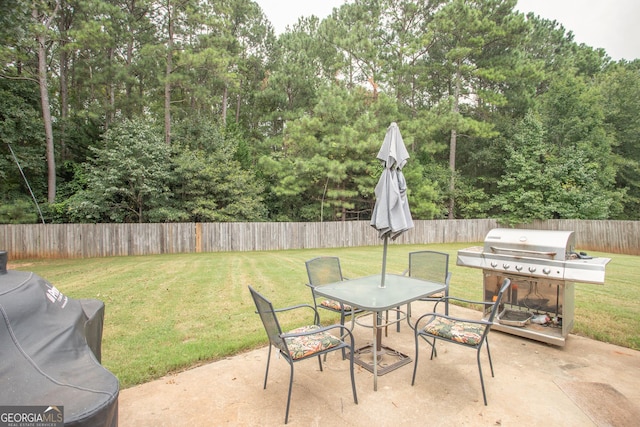 704 Stonecrest Ln, Loganville, GA 30052 - view of patio / terrace with outdoor dining space, a grill, and view of scattered trees