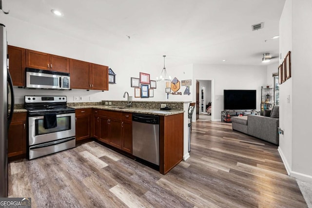 870 Mayson Turner Rd NW Unit 1111, Atlanta, GA 30314 - kitchen with stainless steel appliances, a sink, a peninsula, wood finished floors, and recessed lighting