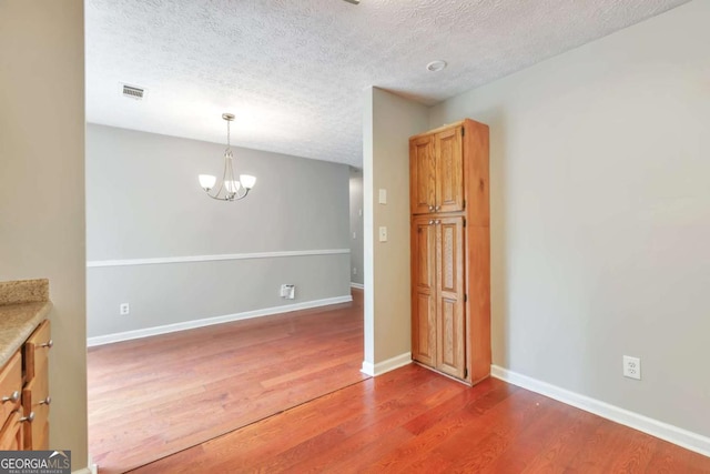 744 Martin Rd, Stone Mountain, GA 30088 - unfurnished room with wood finished floors, a textured ceiling, and a chandelier